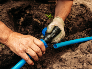 irrigation specialist fixing cracked line due to shifting soil and heat