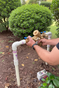 Lawn care specialist repairing backflow in Dallas, TX
